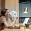 Young woman with a cute white dog working on a laptop in the home office